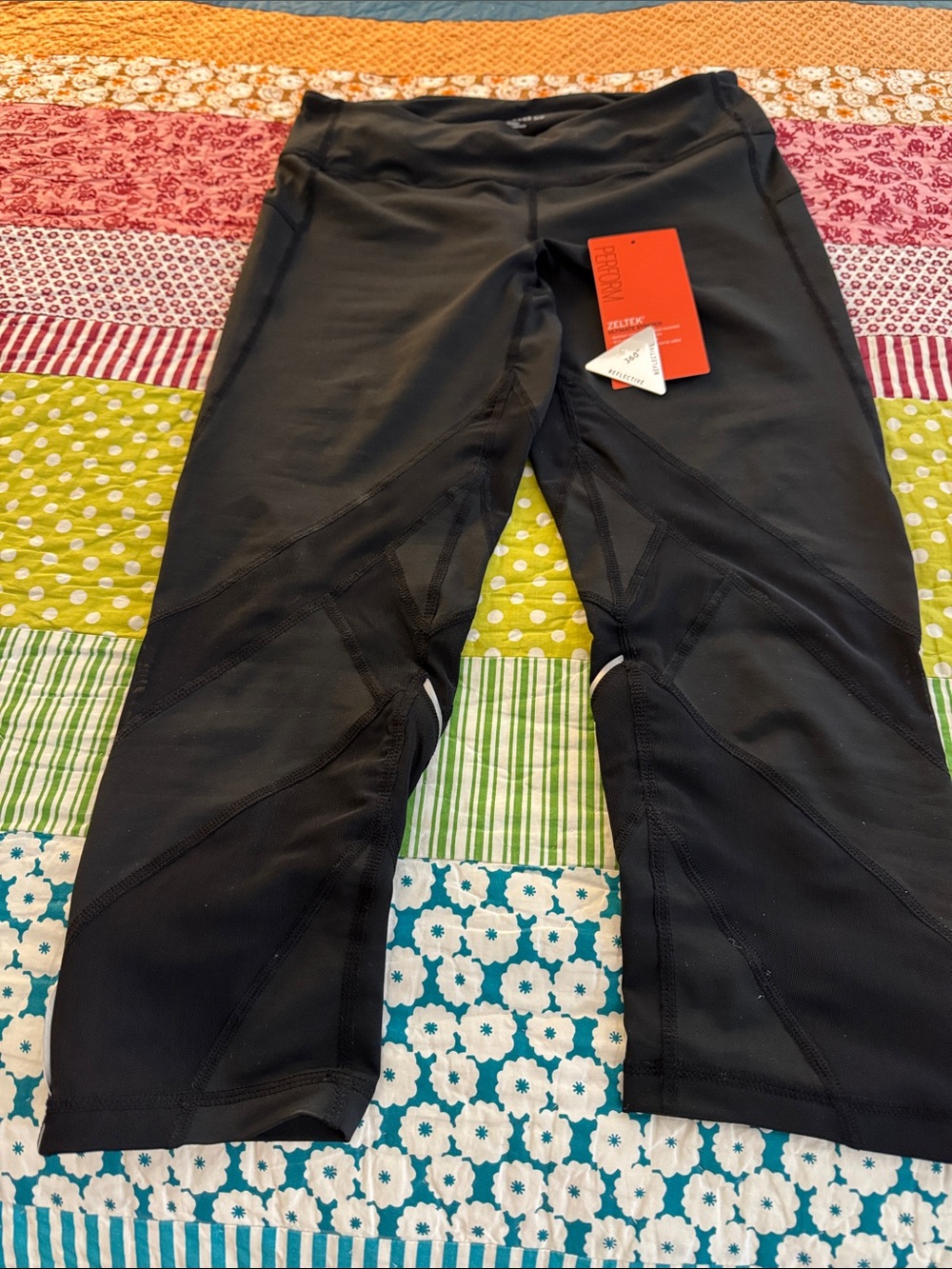 Zella black capri leggings with reflective piping and front and back pockets.
